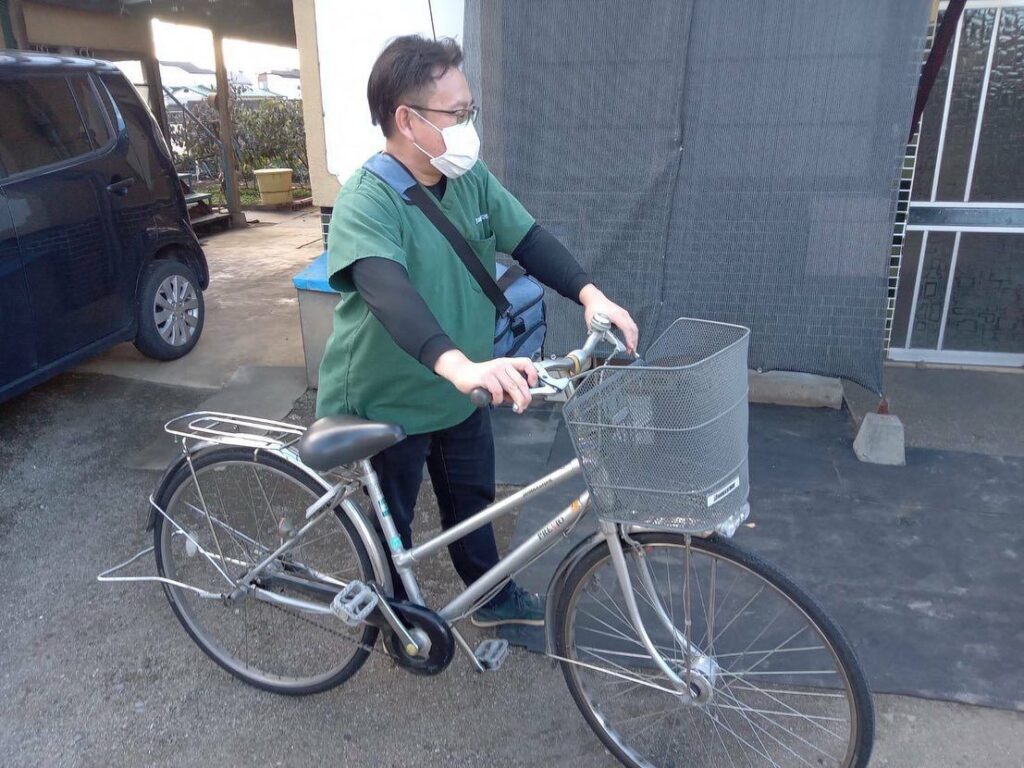 自転車を押して、訪問へ向かう恵川先生