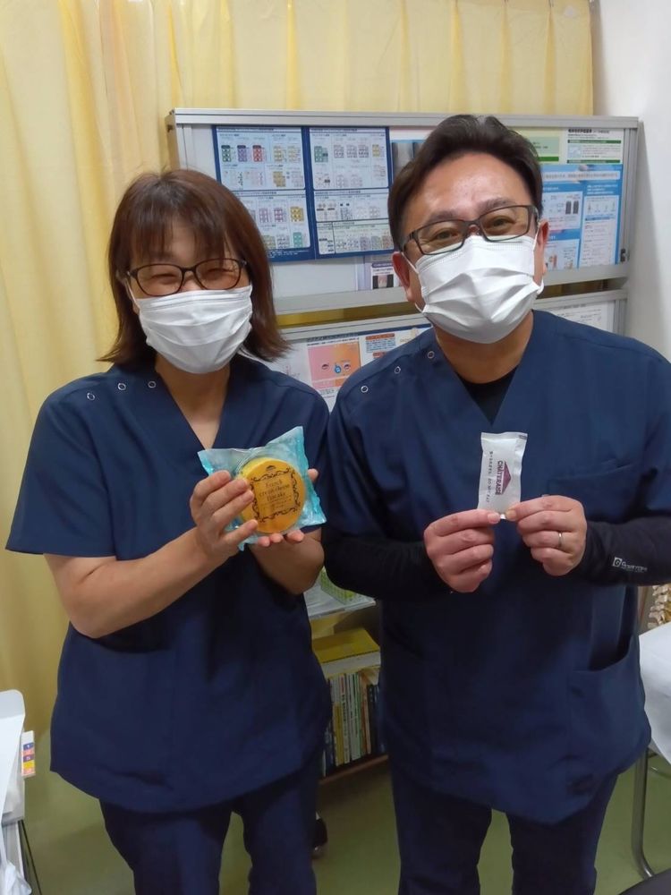 スタッフの方と並んで、笑顔で写る恵川先生